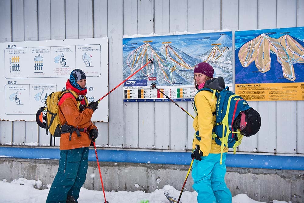 Adam U and Tess Golling inspect the trail map at the bottom of a closed lift.